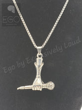 Load image into Gallery viewer, A silver pendant necklace featuring a hand holding a microphone, displayed on a black textured background with a watermark logo in the top left corner.

